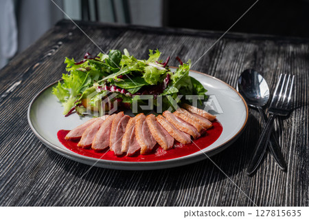 Roasted duck cut into pieces on a plate. Roasted duck cut into pieces on a plate. 127815635