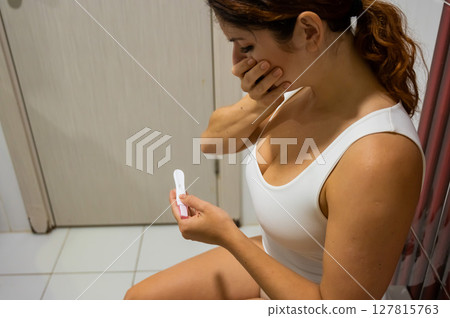 Woman upset by pregnancy test result. Woman upset by pregnancy test result. 127815763