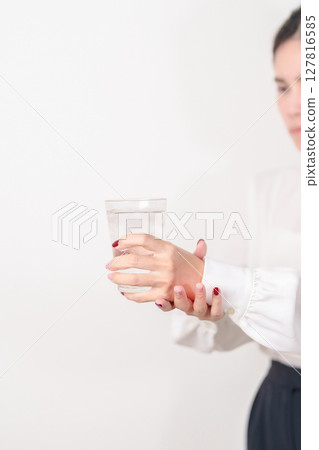 Business woman having Tremor hand during hold water glass. Parkinson disease April awareness month, Carpal Tunnel Syndrome, rheumatoid and brain injury, Neurological disorder and health care concept 127816585