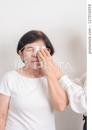 Elderly Woman with Eye protecting by Eye Pad for concepts of Eye disease, Cataract, Glaucoma, Age Related Macular Degeneration, Diabetic Retinopathy, Vitreous, Conjunctivitis, World Glaucoma day 127816958