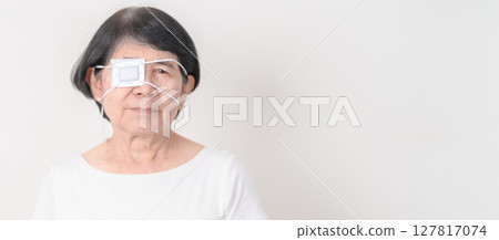 Elderly Woman with Eye protecting by Eye Pad for concepts of Eye disease, Cataract, Glaucoma, Age Related Macular Degeneration, Diabetic Retinopathy, Vitreous, Conjunctivitis, World Glaucoma day Elderly Woman with Eye protecting by Eye Pad for concepts of Eye disease, Cataract, Glaucoma, Age Related Macular Degeneration, Diabetic Retinopathy, Vitreous, Conjunctivitis, World Glaucoma day 127817074