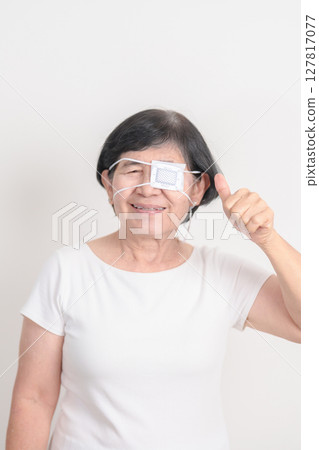 Elderly Woman with Eye protecting by Eye Pad for concepts of Eye disease, Cataract, Glaucoma, Age Related Macular Degeneration, Diabetic Retinopathy, Vitreous, Conjunctivitis, World Glaucoma day Elderly Woman with Eye protecting by Eye Pad for concepts of Eye disease, Cataract, Glaucoma, Age Related Macular Degeneration, Diabetic Retinopathy, Vitreous, Conjunctivitis, World Glaucoma day 127817077