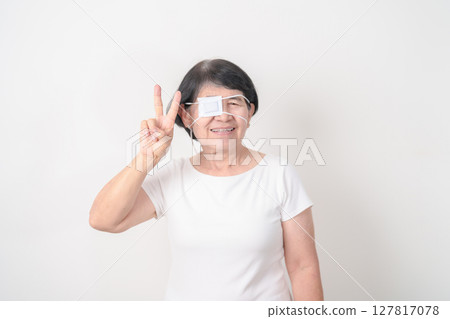 Elderly Woman with Eye protecting by Eye Pad for concepts of Eye disease, Cataract, Glaucoma, Age Related Macular Degeneration, Diabetic Retinopathy, Vitreous, Conjunctivitis, World Glaucoma day Elderly Woman with Eye protecting by Eye Pad for concepts of Eye disease, Cataract, Glaucoma, Age Related Macular Degeneration, Diabetic Retinopathy, Vitreous, Conjunctivitis, World Glaucoma day 127817078