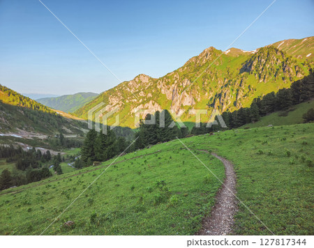 Hiking path through a green mountain slope Hiking path through a green mountain slope 127817344