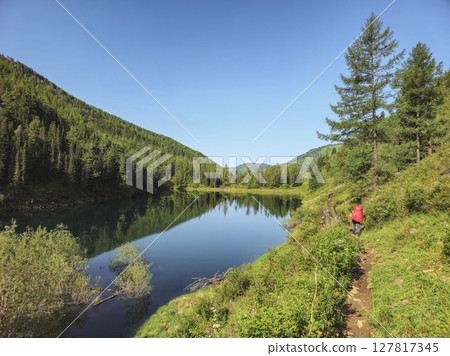 Hiking trail along the forest slope and mountain lake Hiking trail along the forest slope and mountain lake 127817345