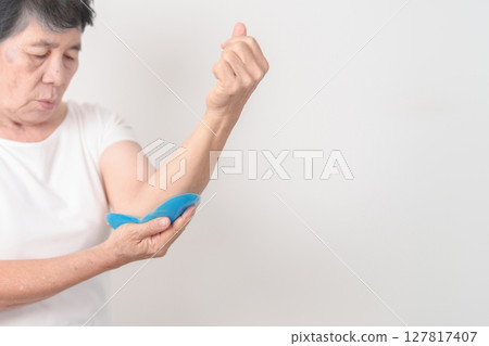 Elderly Woman having elbow ache and Edema with Cold Gel pack  for concepts of Tennis Elbow, muscle pain and Sprain, lateral epicondylitis, Bursitis, injury, Senior Health care and medical 127817407