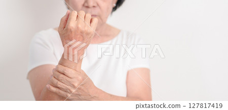 Elderly Woman having wrist pain with Medicated pain relief patch plaster for Carpal Tunnel Syndrome, Wrist Tendinitis, muscle ache, De Quervain s tenosynovitis, Hand Osteoarthritis and Senior health 127817419