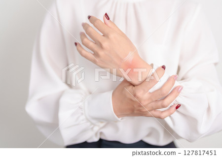 Woman having wrist pain with Medicated pain relief patch plaster for Carpal Tunnel Syndrome, Wrist Tendinitis ache, De Quervain s tenosynovitis, ergonomic, Hand Osteoarthritis and Office syndrome 127817451