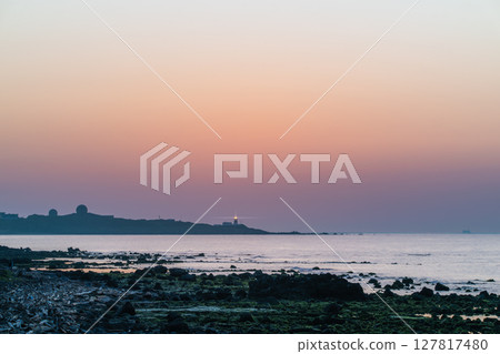 Spring Sunset View with Lighthouse at Shimen Coast, New Taipei City, Taiwan. 127817480