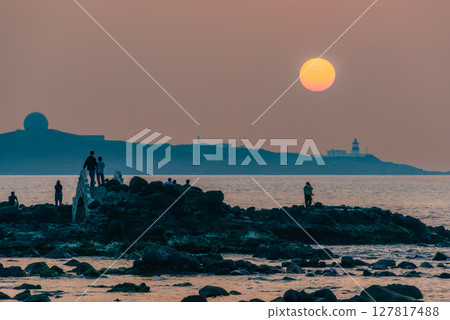 Sunset View at Shimen Coast Taiwan with Tourists Capturing the Scenic Moment. Sunset View at Shimen Coast Taiwan with Tourists Capturing the Scenic Moment. 127817488