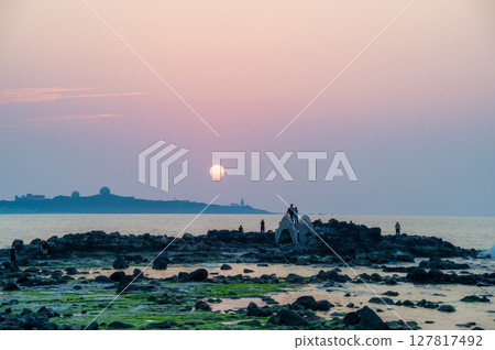 Spring Sunset Crowd at Fugui Cape Lighthouse in Shimen, New Taipei City, Taiwan. 127817492