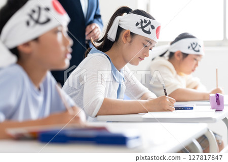 Children studying at a cram school wearing headbands that say "sure victory" 127817847