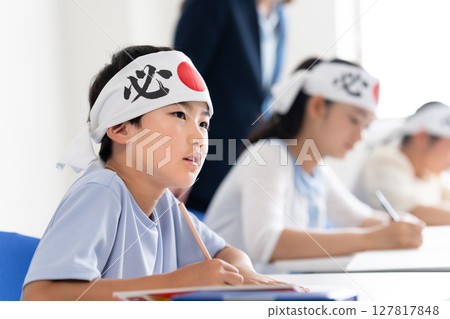 Children studying at a cram school wearing headbands that say "sure victory" 127817848