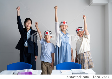 Students and teachers raising their hands in a cram school 127817857