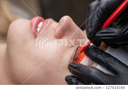 Caucasian woman undergoing eyelash lamination procedure.  127818160