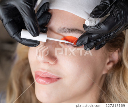 Caucasian woman undergoing eyelash lamination procedure.  127818169