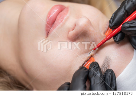 Caucasian woman undergoing eyelash lamination procedure. Caucasian woman undergoing eyelash lamination procedure. 127818173