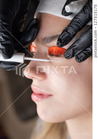 Caucasian woman undergoing eyelash lamination procedure.  127818178