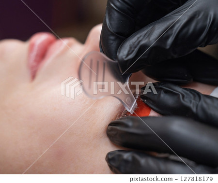 Caucasian woman undergoing eyelash lamination procedure. Caucasian woman undergoing eyelash lamination procedure. 127818179