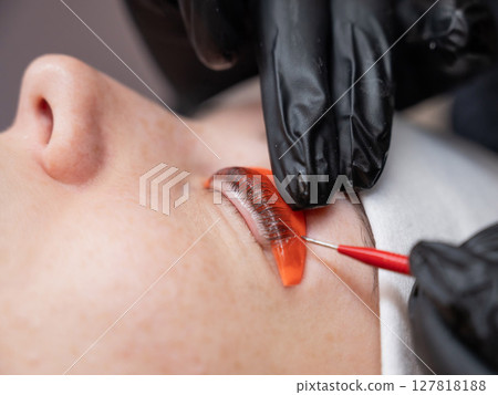 Caucasian woman undergoing eyelash lamination procedure.  127818188