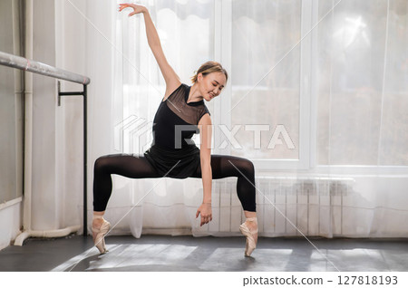 A beautiful Asian woman is dancing at the barre. Ballet dancer. 127818193