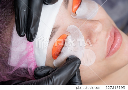 Caucasian woman undergoing eyelash lamination procedure.  127818195