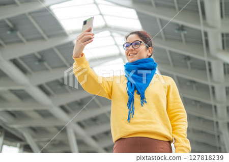 Happy caucasian woman is walking and talking on video communication on the phone Happy caucasian woman is walking and talking on video communication on the phone 127818239