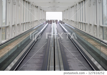 Empty travelator with glass handrails. Without people. Mechanized pedestrian crossing Empty travelator with glass handrails. Without people. Mechanized pedestrian crossing 127818252