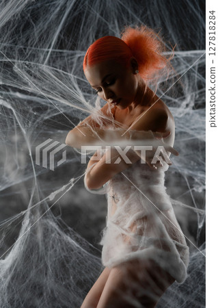 Red-haired woman caught in an intricate net trap surrounded by webs Red-haired woman caught in an intricate net trap surrounded by webs 127818284