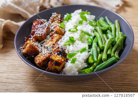 plate of fried tofu with sesame seeds, rice and green beans 127818507