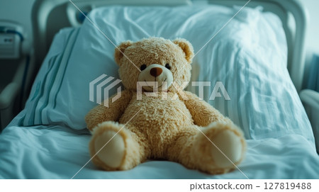 Teddy bear sits on a hospital bed, offering comfort and companionship during illness, providing emotional support to a young patient undergoing medical treatment Teddy bear sits on a hospital bed, offering comfort and companionship during illness, providing emotional support to a young patient undergoing medical treatment 127819488