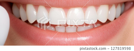 Close up view highlighting a perfect smile with healthy white teeth and soft pink lips, illustrating the importance of good oral hygiene and dedicated dental care Close up view highlighting a perfect smile with healthy white teeth and soft pink lips, illustrating the importance of good oral hygiene and dedicated dental care 127819598