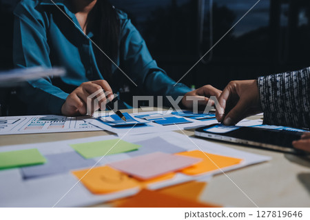 Group of young application developers analyzing uxui mobile app templates during a working meeting 127819646