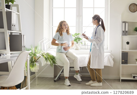 Patient With Stomach Pain In Consultation With Doctor Or Nurse At Hospital Patient With Stomach Pain In Consultation With Doctor Or Nurse At Hospital 127820689