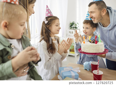 Happy birthday big family party with cake, overjoyed child girl getting birthday surprise gift Happy birthday big family party with cake, overjoyed child girl getting birthday surprise gift 127820725