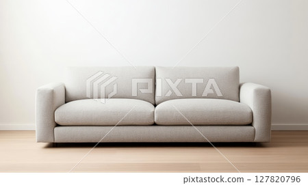 Comfortable sofa in a minimalist living room setting with a blank wall providing ample copy space, ideal for showcasing interior design concepts and furniture advertisements 127820796