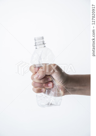 A man's hand crushing an empty plastic bottle A man's hand crushing an empty plastic bottle 127820917