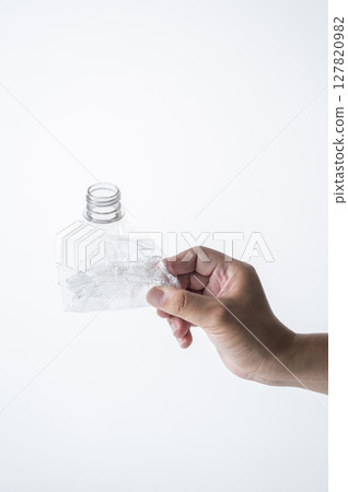 Man's hand holding a crushed plastic bottle Man's hand holding a crushed plastic bottle 127820982