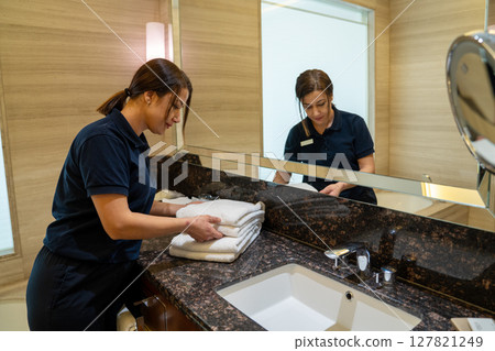 Housekeeper cleans the bathroom and replace the towels  127821249