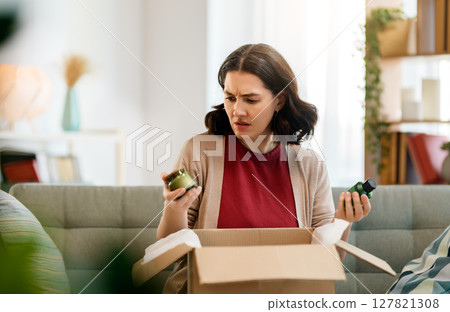 Woman is unpacking cardboard 127821308