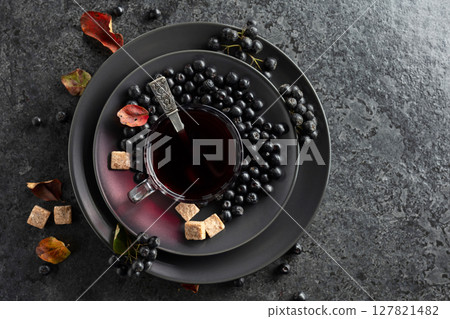 Black chokeberry juice, fresh berries, and pieces of brown sugar. Black chokeberry juice, fresh berries, and pieces of brown sugar. 127821482