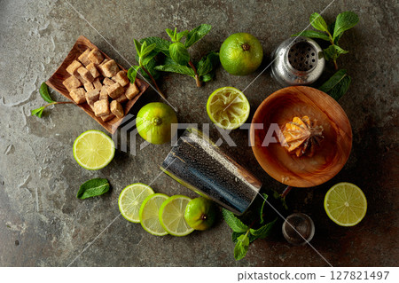 Wooden citrus squeezer, shaker, and ingredients for making summer refreshing drinks. Wooden citrus squeezer, shaker, and ingredients for making summer refreshing drinks. 127821497