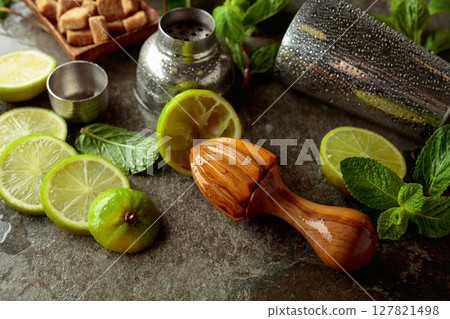 Wooden citrus squeezer, shaker, and ingredients for making summer refreshing drinks. 127821498