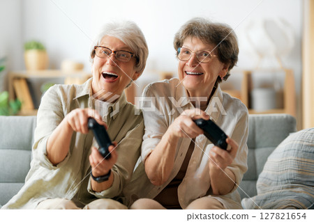 Two senior women playing console game Two senior women playing console game 127821654