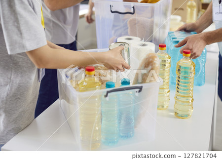 Volunteers of non profit organization prepare food and other supplies for homeless and refugees 127821704