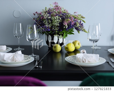 An Elegant Dining Table Beautifully Graced with Gorgeous Flowers and Assorted Fresh Fruits 127821833