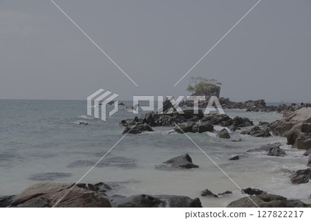 A Serene Coastal Landscape Featuring a Rocky Shoreline and Overcast, Cloudy Skies Above A Serene Coastal Landscape Featuring a Rocky Shoreline and Overcast, Cloudy Skies Above 127822217