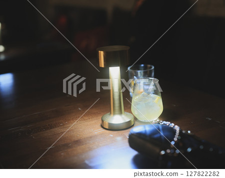 An aesthetic and ambient bar scene featuring drinks alongside a stylishly designed lamp An aesthetic and ambient bar scene featuring drinks alongside a stylishly designed lamp 127822282