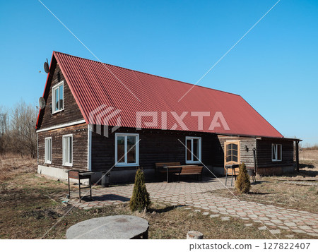 Charming Wooden House with a Bright Red Roof Surrounded by Scenic and Picturesque Nature 127822407