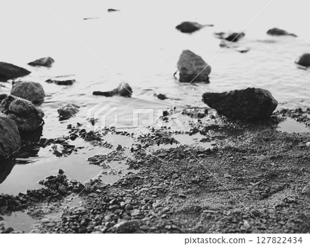 Serene Shoreline Beautifully Positioned Rocks on a Tranquil Water Edge of the Coast 127822434